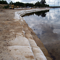 Close-up van SoilTain Bags als kustbescherming aan de rand van het meer