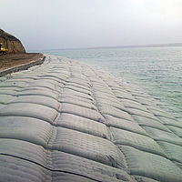 Zandzakken aan de waterkant voor oeverbescherming
