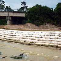 Zandzakken aan de rivierrand voor oeverbescherming