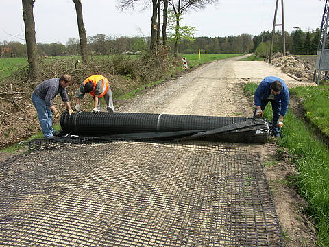 Basetrac Grid is being laid by several workers along a path