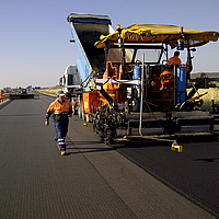 Het asfalteren van de geprepareerde HaTelit-laag met een teermachine