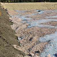 Basetrac Grid geogrid op een bouwplaats, waar al zand of grind overheen is gestrooid