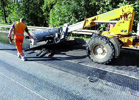 Construction machinery is carrying out concrete deck refurbishment using asphalt and SamiGrid.