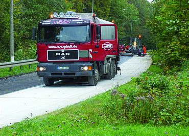 Road construction carried out by various construction machines and workers.