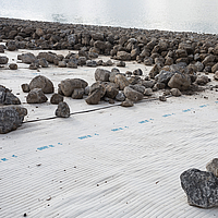 Tektoseal® zandgeocomposiet - Gedetailleerd beeld van het geocomposiet onder stenen