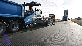 Teermachine legt asfalt op HaTelit XP wapeningsrooster