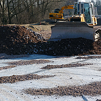 Bulldozer aan het werk, puin aan het ruimen op een bouwterrein